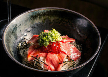 WAGYU DONBURI WAGYU DONBURI traditional steamed rice bowl topped with thin slices of A5 joshu wagyu beef, ikura, spring onion & yakiniku sauce